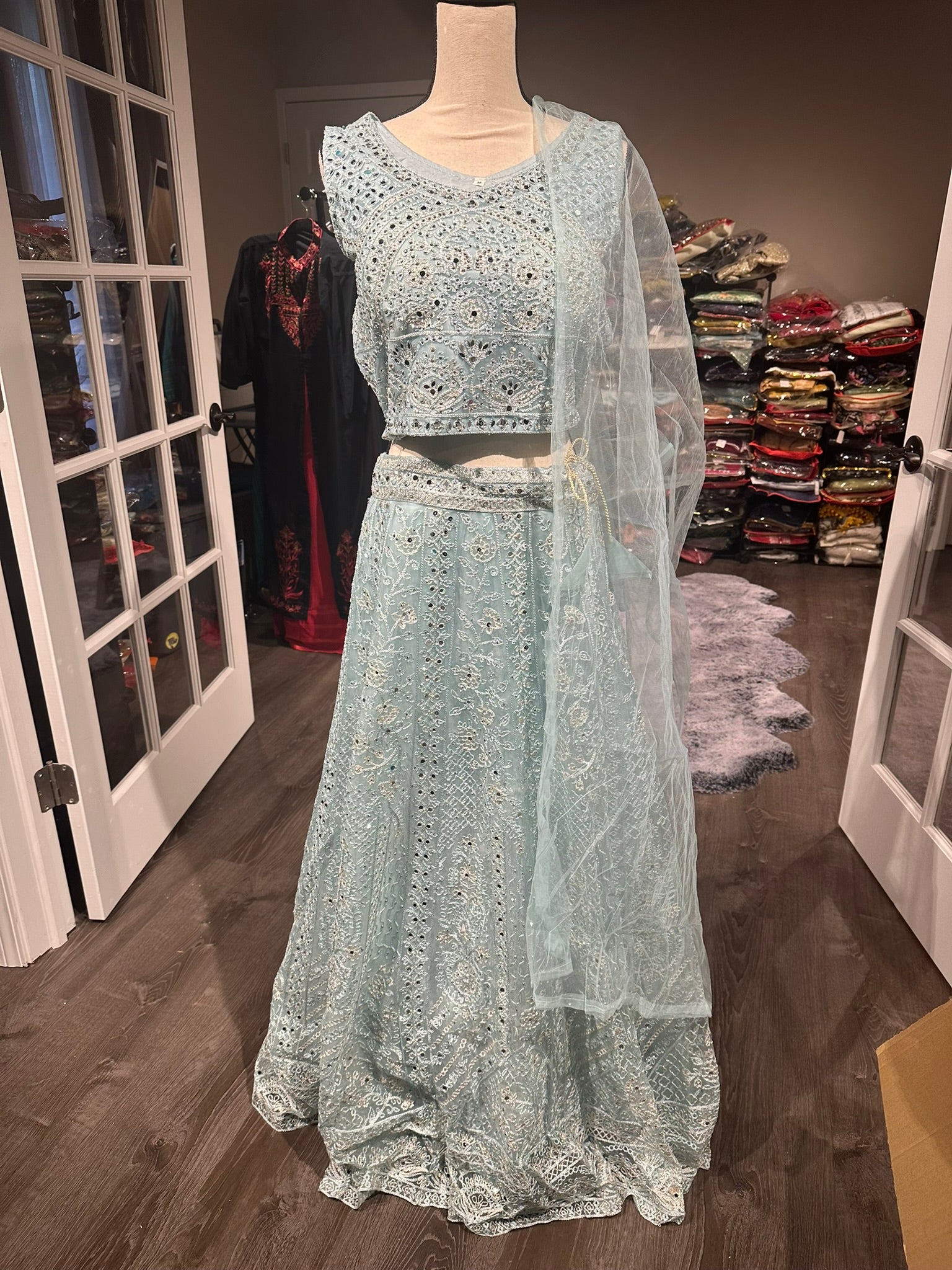 Light blue net lehenga with crystal stones and real mirror work.