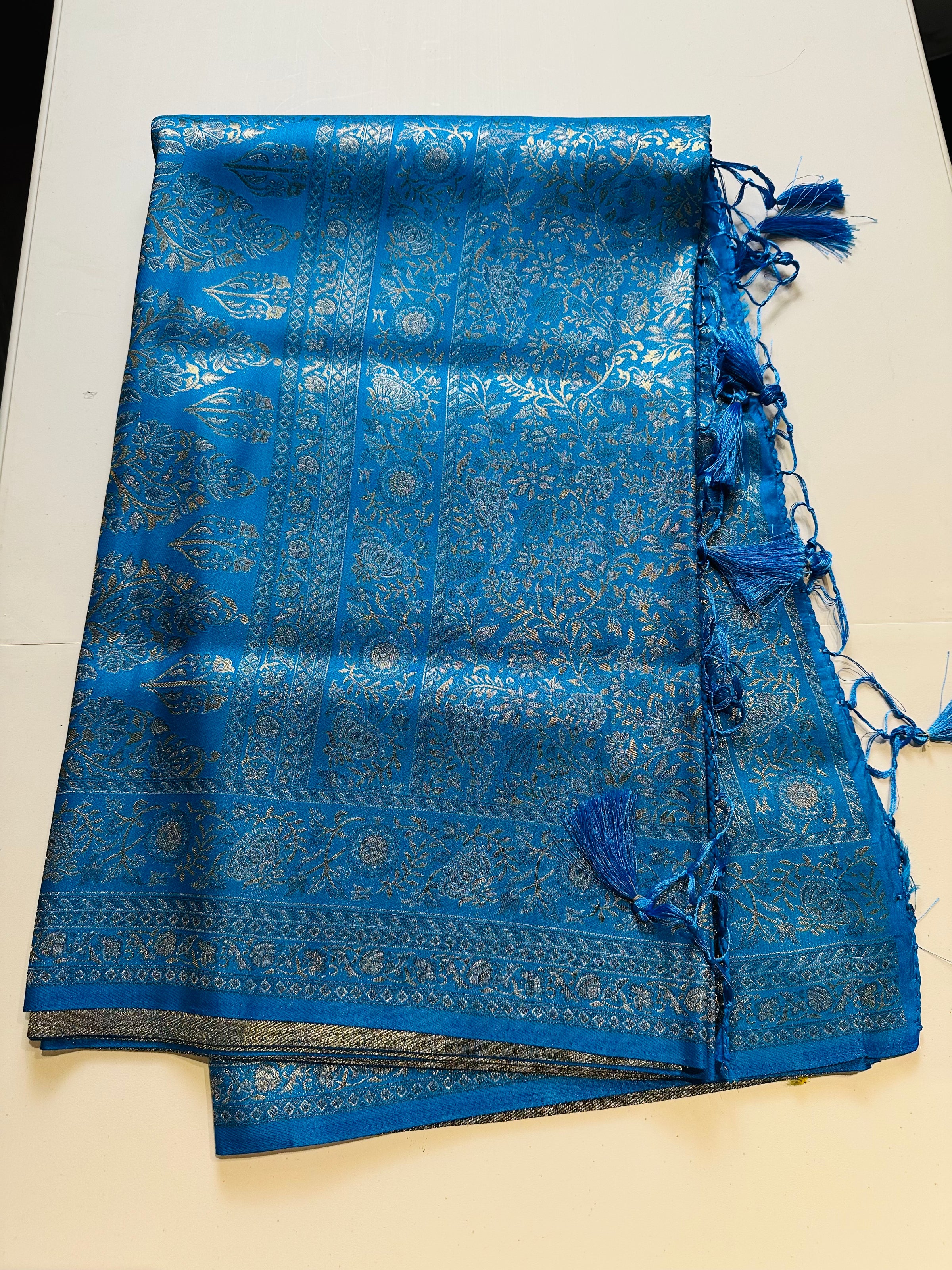Blue silk saree with silver woven floral motifs and tassel pallu